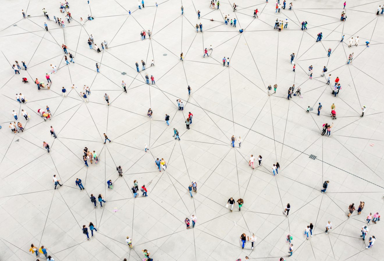 A macro image of many people standing on a white surface connected by black lines