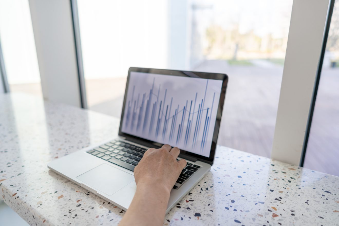 A man enters data into a laptop, which returns a graph
