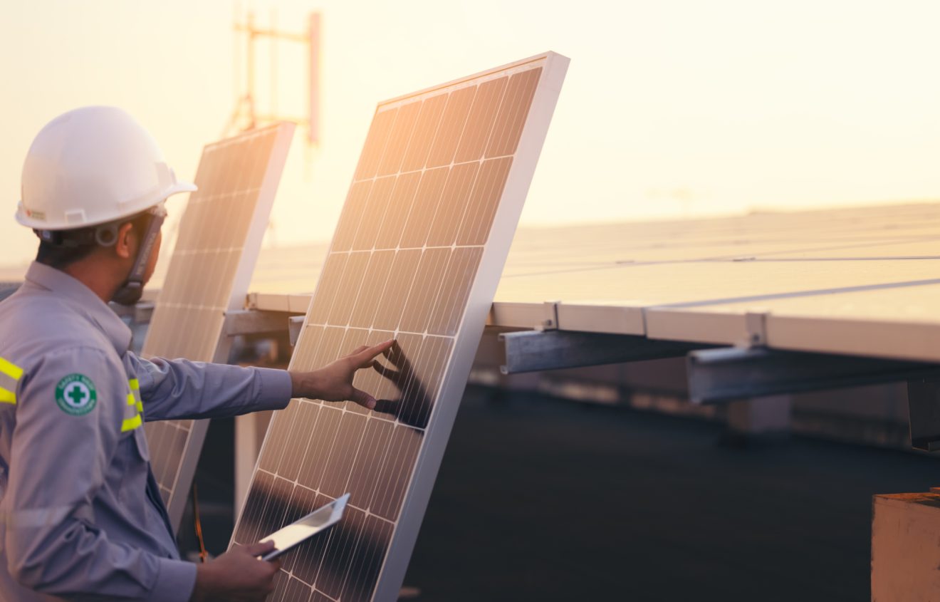 A solar engineer inspects a panel in the field