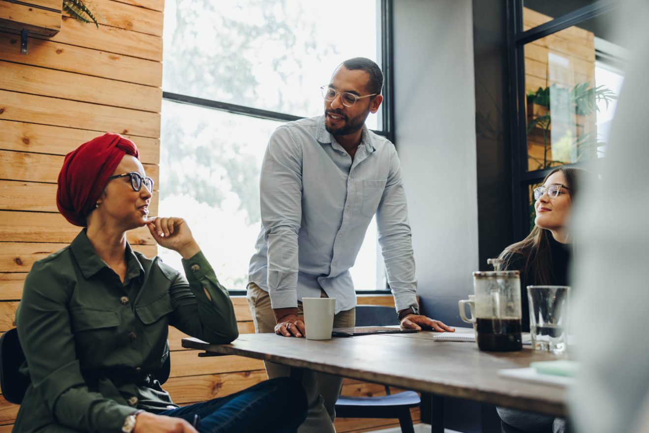 Three people in a casual meeting, working together