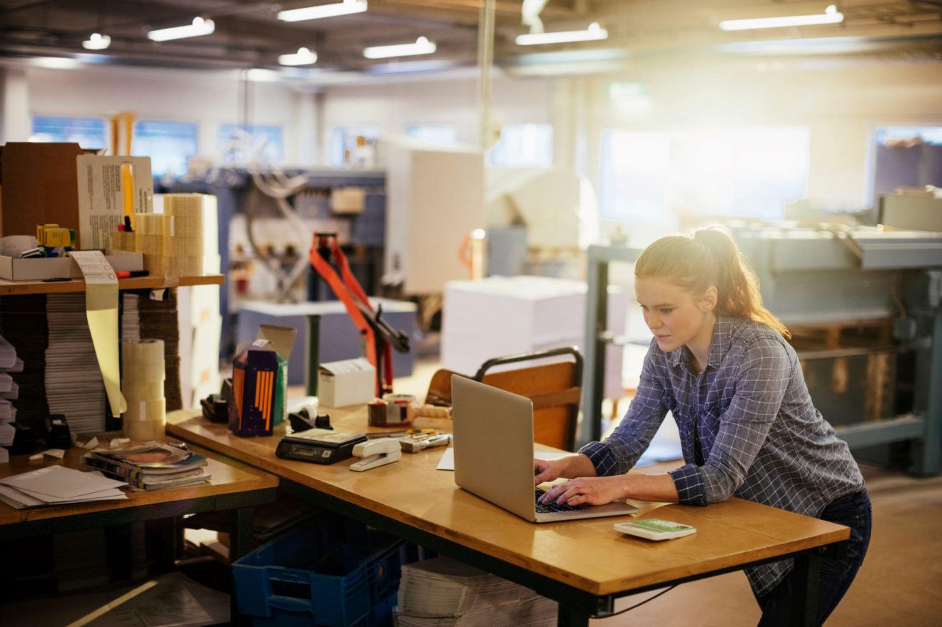 Woman working at a standing desk with red hair
