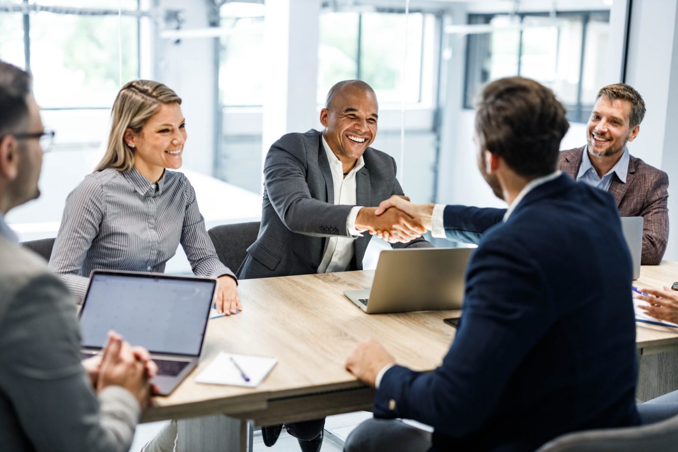 Happy businessmen shaking hands during a meeting in the office