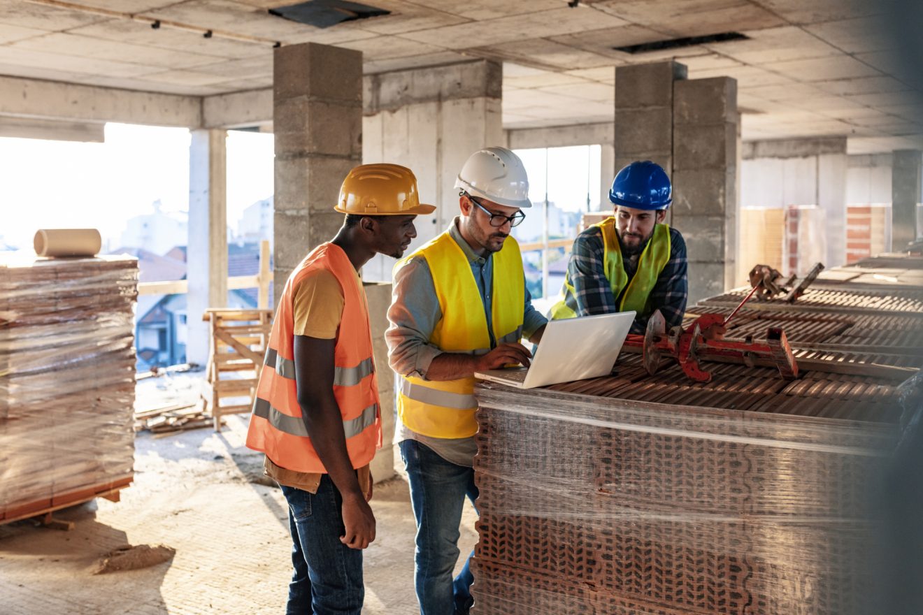 A team of construction workers checking their laptop on-site