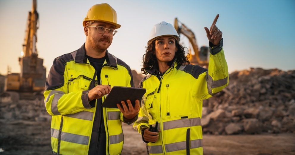 Male Civil Engineer Talking To Female Inspector And Using Tablet