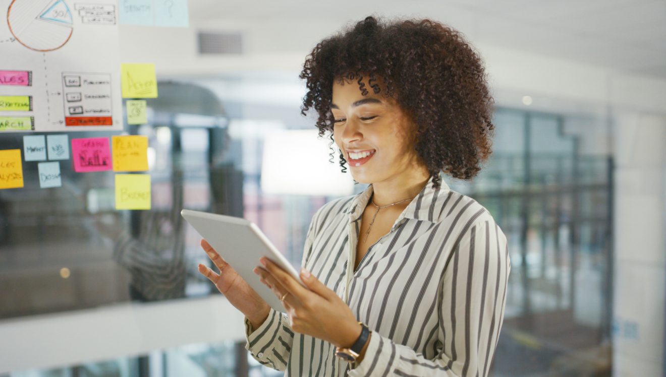young businesswoman using a tablet while having a brainstorming session in a modern office