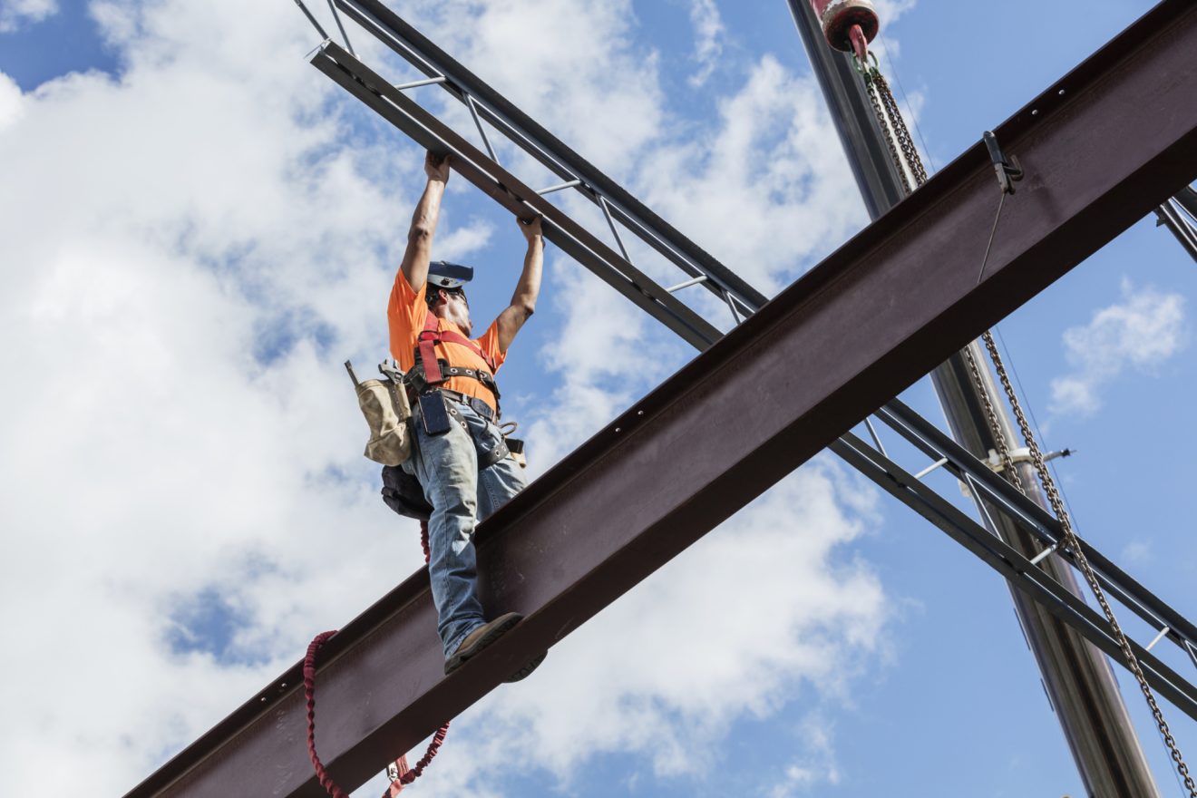 A construction worker sits on scaffolding