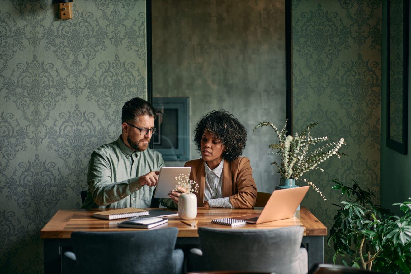 Two people reference a tablet