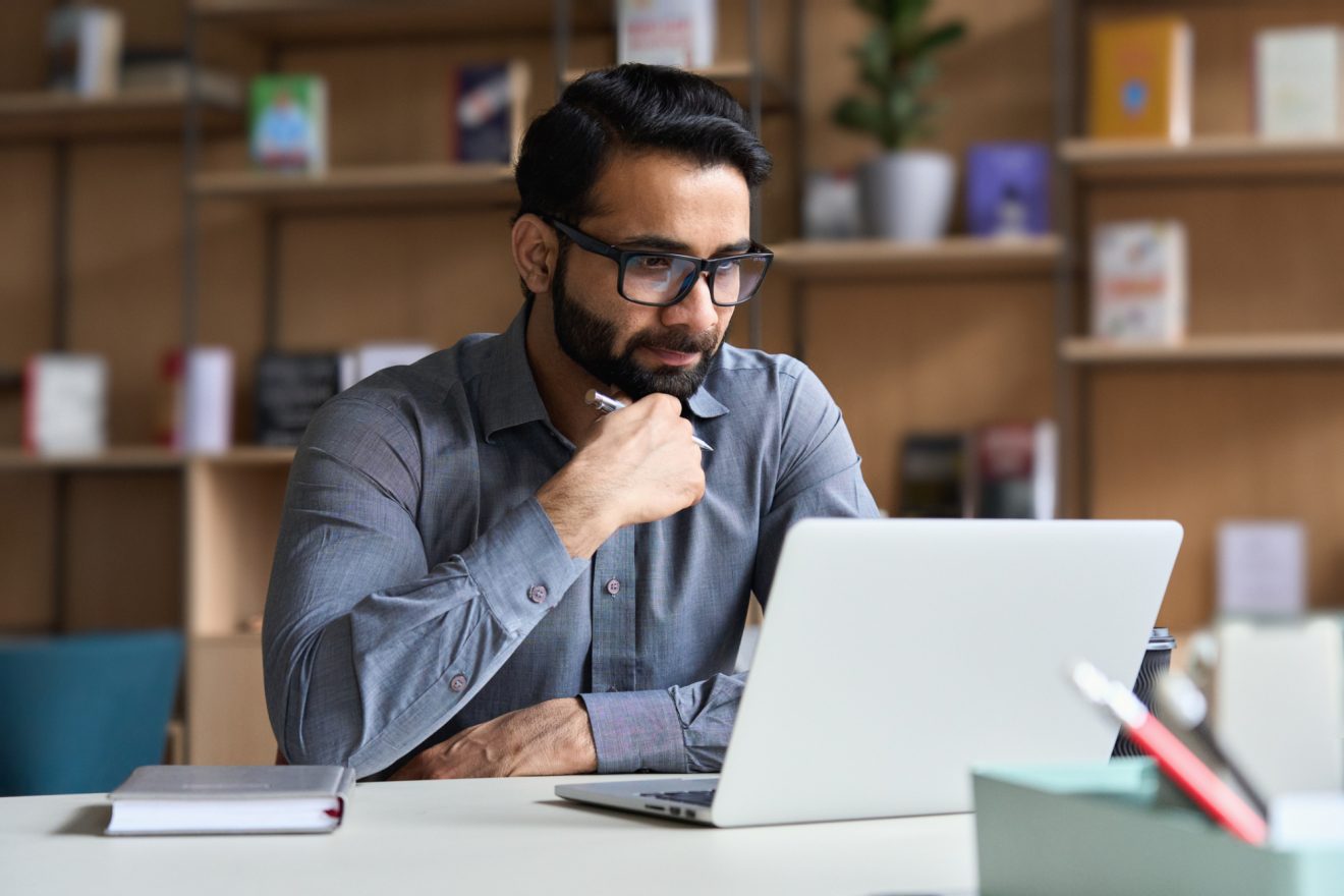 A man listens to a webinar discussion on his laptop