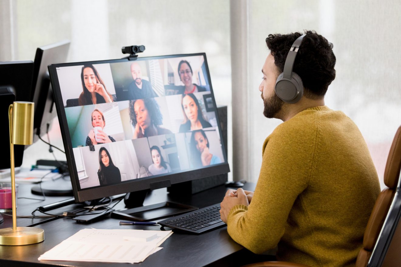 A man participates in a video call from his desk