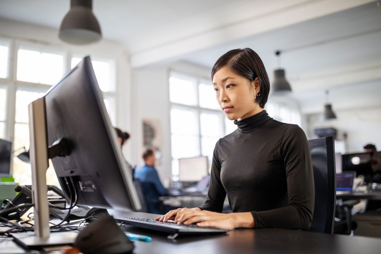 A woman works at her computer